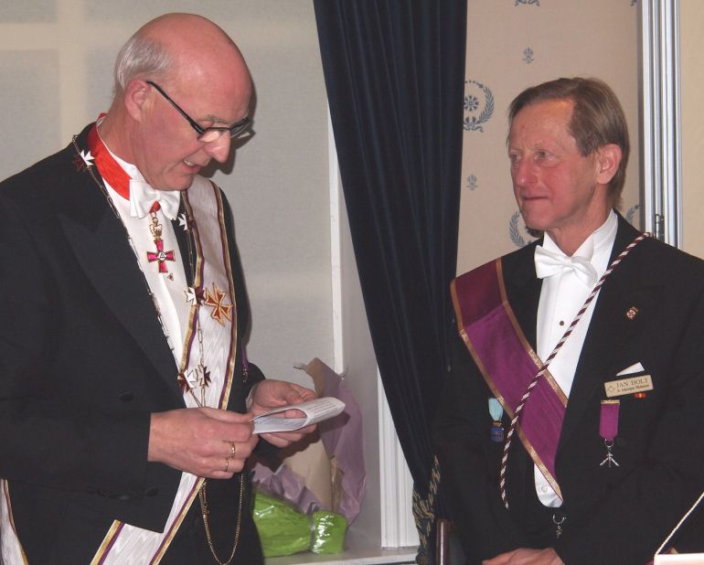 Prov.Mester Per Trygve Kongsnes var installasjonsforretter ved innsettelsen av br. Jan Holt som ny Ordførende Broder i Bodø Kap. broderforening.|Den avtroppende Ordf.br. Rolf Schjem (t.h.) og påtroppende Jan Holt er venner og kamerater gjennom mange år, både i loge og på arbeidssted. Her utveksler de blomster, takk og lykkeønskninger.